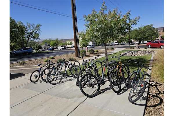A row of bicycles are parked on a sidewalk. at 605 Place Student Housing & Co-Living, St George, 84770